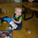 Isaac opening a gift from Tante and Uncle Andy
