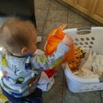 Isaac helps put things in baskets now