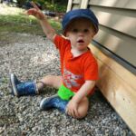 Isaac loves playing with the rocks at the cottage