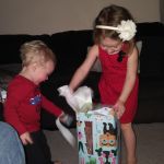 Finley helping Isaac open his gift