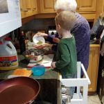 Isaac helping Grandma make dinner