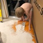 Isaac helping to glue the tiles