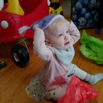 trying to put on her hat